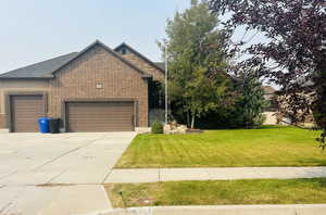 View of front facade featuring a front lawn and a garage