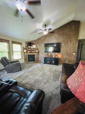 Living room featuring lofted ceiling, carpet flooring, ceiling fan, and a textured ceiling