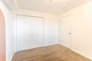 Unfurnished bedroom featuring a closet and carpet floors