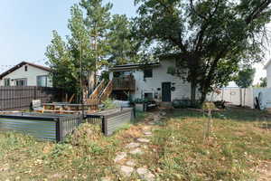 Rear view of house with a yard and a wooden deck