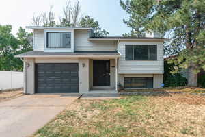 Tri-level home featuring a front lawn and a garage