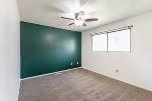 Spare room with ceiling fan and carpet