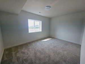 Carpeted spare room featuring a textured ceiling