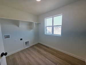 Laundry area with hookup for a washing machine, hardwood / wood-style flooring, and hookup for an electric dryer