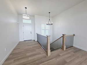 Entrance foyer featuring light hardwood / wood-style flooring and a notable chandelier