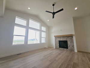 Unfurnished living room with ceiling fan, a tile fireplace, and light hardwood / wood-style flooring