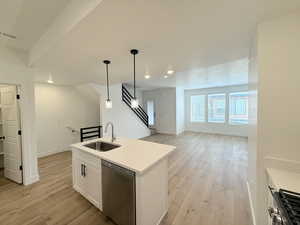 Kitchen featuring pendant lighting,, white shaker slow close cabinetry, quartz counters,  light wood finished floors