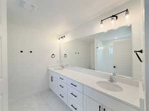 Primary bathroom with double vanity, walk-in shower and quartz counters