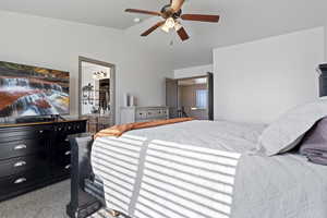 Bedroom with ceiling fan, carpet flooring, a spacious closet, and ensuite bath