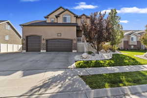 View of front facade featuring a garage and a front lawn