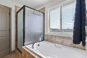 Bathroom with independent shower and bath and tile patterned floors