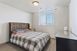 Bedroom featuring dark colored carpet