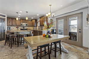 Dining room with light tile patterned flooring and an inviting chandelier