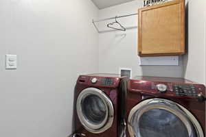 Clothes washing area with washer and dryer and cabinets