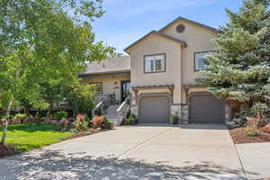 Front of home with beautiful landscaping, stonework and cute details.