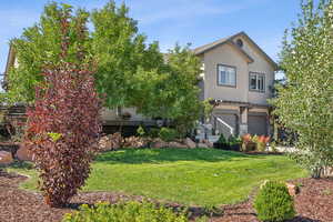 Front of home with beautiful landscaping, stonework and cute details.