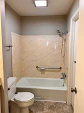 Bathroom featuring toilet and tiled shower / bath combo