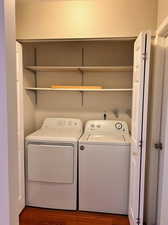 Washroom featuring washer and clothes dryer and wood-type flooring