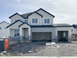 View of front of property featuring a garage, a shingled roof, and board and batten siding