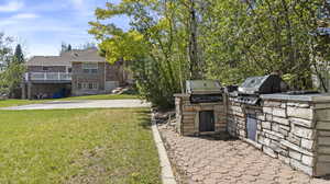 View of yard featuring exterior kitchen and a balcony