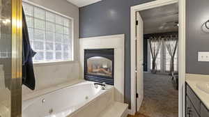 Bathroom with plenty of natural light, vanity, a fireplace, and a washtub