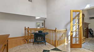 Interior space with a high ceiling, wood-type flooring, a fireplace, and a wood stove