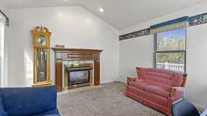 Carpeted living room with a high end fireplace and lofted ceiling