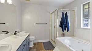 Full bathroom with vanity, toilet, wood-type flooring, and separate shower and tub