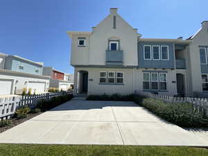 View of front of home featuring a garage and a balcony