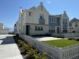 Back of house with a mountain view and a yard