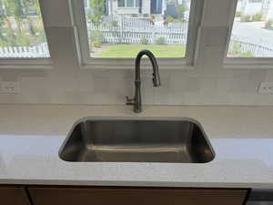 Room details featuring light stone counters and sink