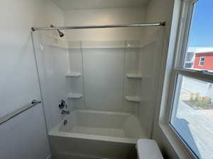 Bathroom with a textured ceiling, toilet, and bathing tub / shower combination