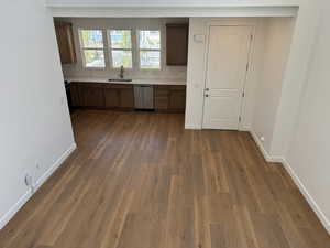 Kitchen featuring sink, light hardwood / wood-style floors, tasteful backsplash, and stainless steel dishwasher