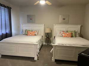 Bedroom with dark colored carpet and ceiling fan