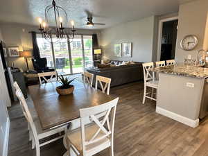 Dining area with a textured ceiling, luxury vinyl plank floors, and chandelier