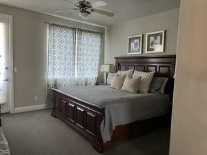 Carpeted bedroom featuring a textured ceiling and ceiling fan