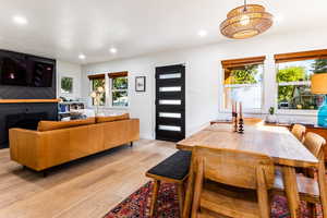 Interior space featuring a healthy amount of sunlight, light hardwood / wood-style floors, a notable chandelier, and a fireplace