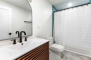 Bathroom featuring vanity, toilet, and a shower with curtain