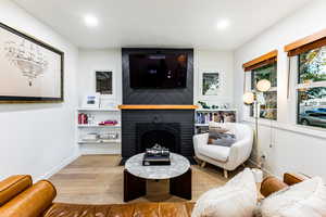 Living room with a fireplace and light hardwood / wood-style flooring