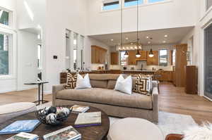 Living room featuring a towering ceiling, sink, and light hardwood / wood-style floors