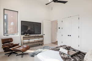 Bedroom with ceiling fan, a closet, a towering ceiling, and multiple windows