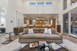 Living room with a towering ceiling and light hardwood / wood-style floors