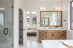 Bathroom featuring independent shower and bath, vanity, and a wealth of natural light