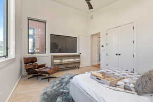 Bedroom featuring ceiling fan, a closet, and light carpet