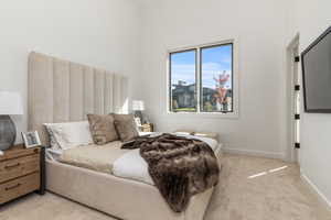 Bedroom featuring light carpet