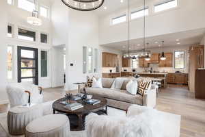 Living room featuring light wood-type flooring, a high ceiling, and plenty of natural light