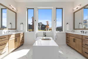 Bathroom with a tub, plenty of natural light, and vanity