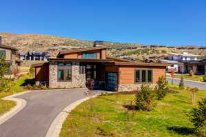 View of front of home featuring a mountain view and a front lawn