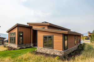 Rear view of house featuring a lawn