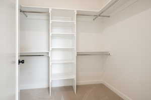 Walk in closet with light colored carpet